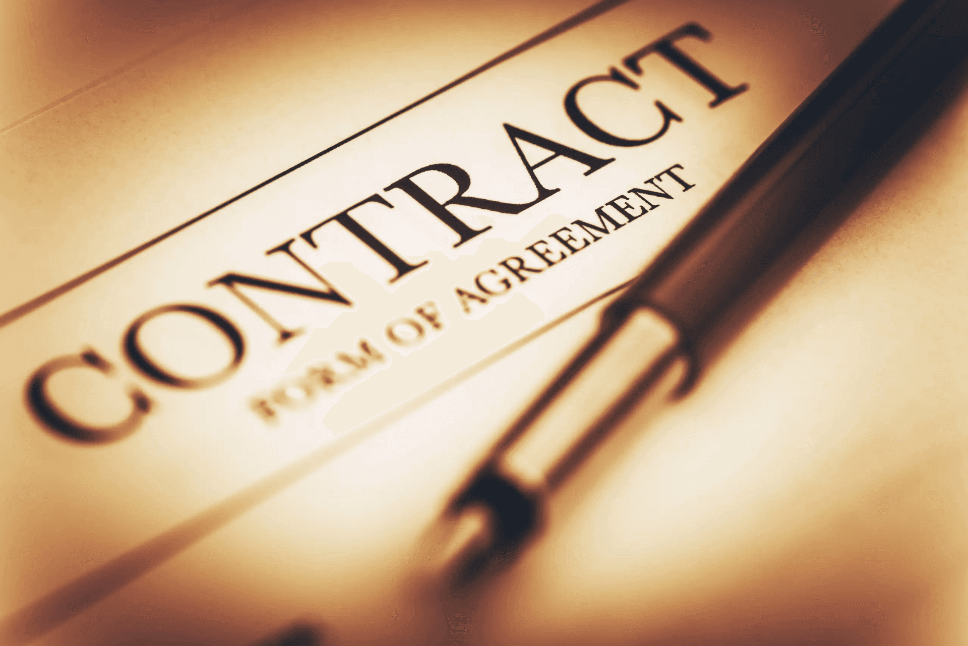 Close-up of a contract document with a pen lying on it.